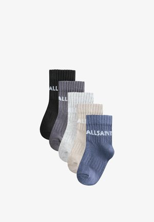 Cinq paires de chaussettes montantes côtelées en noir, gris foncé, gris clair, beige et bleu, chacune avec un texte de logo partiel blanc près du haut.