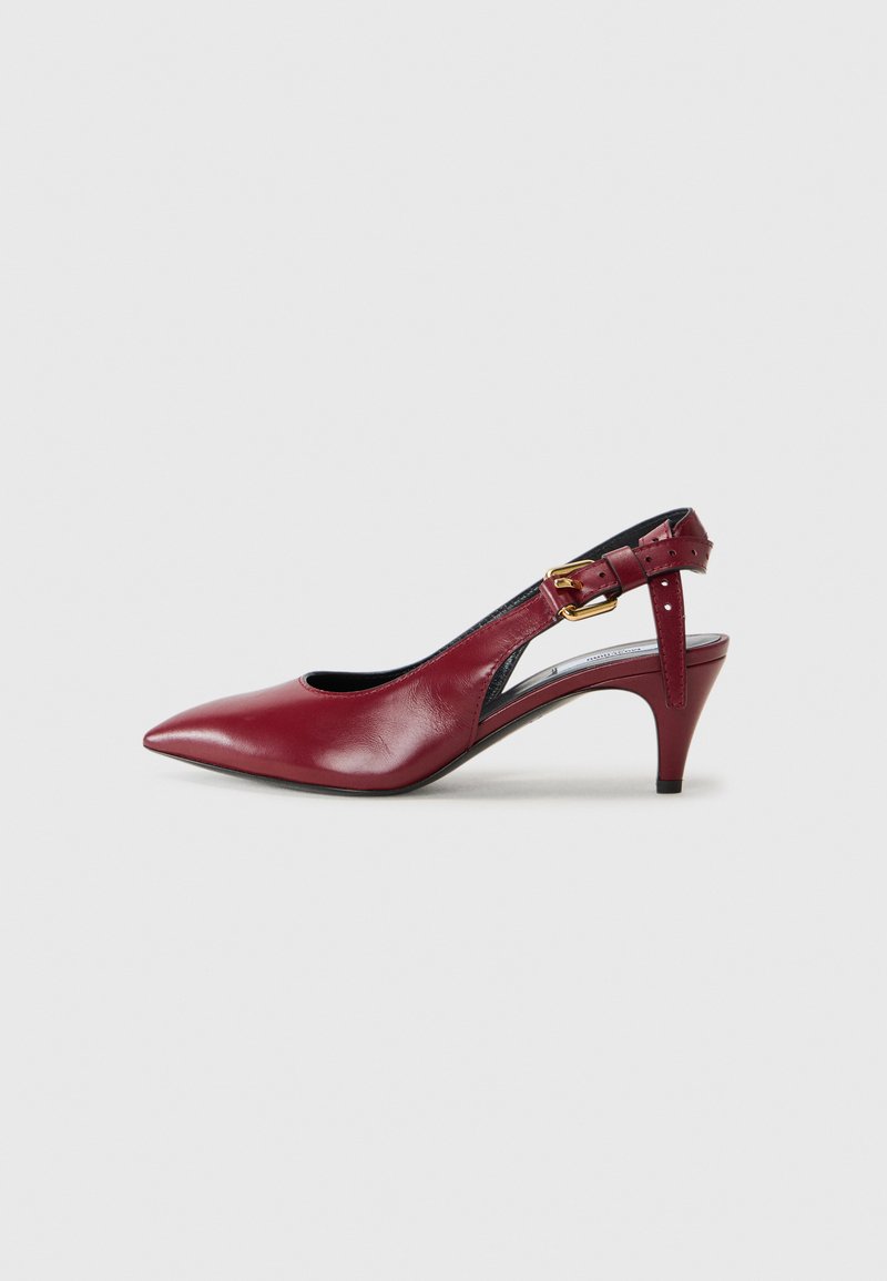 Red leather slingback pump with a pointed toe, curved cutout details, and a thin heel. Features an adjustable strap with a gold buckle.