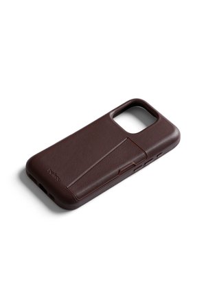 Étui de téléphone en cuir brun foncé avec un support pliable intégré, découpes pour l'appareil photo et les boutons, incliné sur un fond blanc.