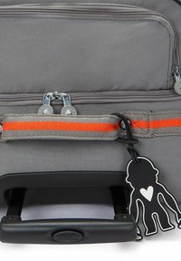 Borsa a tracolla grigia con doppi scomparti con zip, accentuazione arancione e manico in plastica nera con un divertente portachiavi a forma di scimmia.