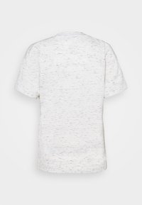 T-shirt blanc à manches courtes avec un motif noir tacheté subtil, vu de dos sur un fond clair uni.