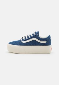 Sneaker in denim con tomaia in tessuto blu, inserti e lacci in pelle bianca, punta rotonda e una spessa suola piattaforma beige.