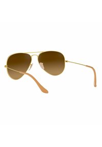 Occhiali da sole aviator con montatura in metallo dorato, lenti marroni e punte delle aste in plastica color marrone chiaro. Include cuscinetti nasali regolabili per il massimo comfort.