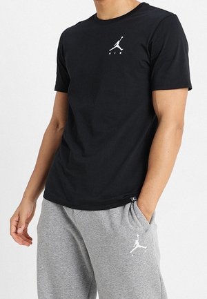 Czarna bawełniana koszulka z białym logo Jumpman i napisem "AIR". W zestawie szare spodnie dresowe z tym samym logo. Luźny krój.