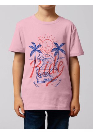 Kind draagt roze T-shirt met een blauwe schedel, twee palmbomen, oranje zonfiguur die surft op golven, en oranje "Ride" tekstontwerp.
