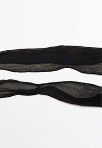 Bandes en tissu noir transparent avec une texture froissée, présentant des bords ondulés. Deux bandes posées parallèlement, affichant un design léger et aérien.