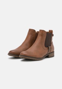 Bottines en cuir marron avec panneaux latéraux élastiques, finition lisse, bout rond et talon bas en bloc. Détails de couture décorative sur le côté.
