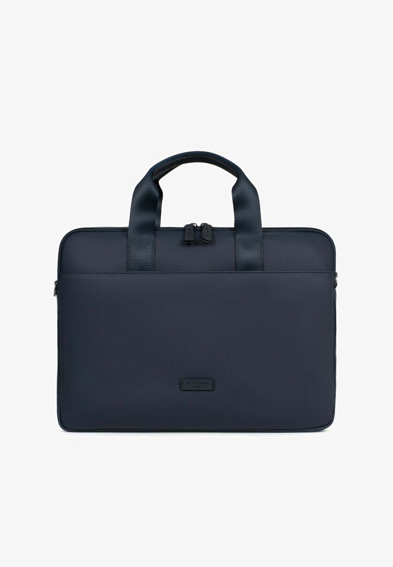 Borsa a tracolla navy realizzata in tessuto texturizzato con manici superiori doppi, chiusura con zip e un'etichetta frontale. Superficie liscia e forma rettangolare.