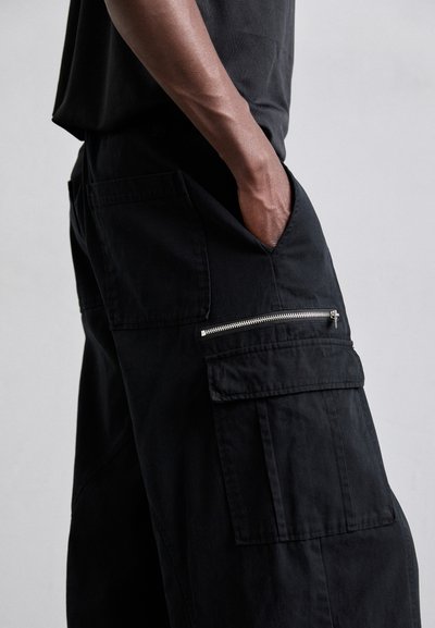 Sorte cargo bukser med flere lommer, inklusive en lynlåslomme i siden. Fremstillet af slidstærkt stof med en afslappet pasform og lige ben.