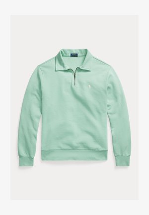 Gaiši zaļš garām piedurknēm džemperis ar apkakli, pusgaru rāvējslēdzēju priekšpusē, ribotām aprocēm un apakšu, kā arī mazu izšūtu Polo Ralph Lauren logotipu uz krūtīm.