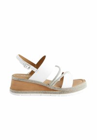 Sandales compensées blanches avec sangle réglable, tige en cuir et bordure argentée étincelante autour de la semelle. Semelle intérieure texturée marron et semelle extérieure blanche.