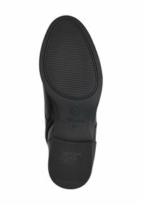 Semelle de chaussure noire avec un motif texturé antidérapant, logo de la marque "Tamaris", taille "37", forme courbée, bords lisses et bout arrondi.