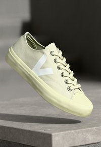 Sneaker in tela giallo chiaro con logo V bianco, occhielli in metallo e suola in gomma texturizzata. Design standard con lacci.