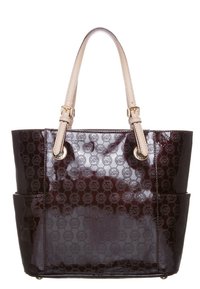 Torebka typu tote w ciemnym burgundzie z lakierowanej skóry, z wytłoczonym wzorem logo, podwójnymi uchwytami oraz złotymi akcentami hardware. Posiada dwie zewnętrzne kieszenie.