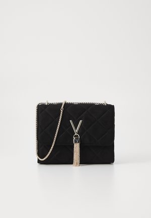 Black quilted suede bag with chain strap, features a V-shaped clasp and a silver tassel detail, compact rectangular shape.