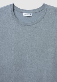 Maglione grigio chiaro con scollatura a girocollo a coste. Realizzato in un tessuto liscio e morbido, privo di motivi o decorazioni. Taglia indicata XL.