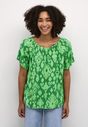 Blusa verde a maniche corte con motivo testurizzato, colletto tondo e vestibilità rilassata. Il tessuto presenta una miscela di tonalità di verde chiaro e scuro.