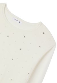Maglione color crema con colletto rotondo, decorato con piccoli chiodini argentati e simil-perle disposti in un motivo a pois.