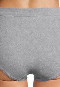 Grijze katoenen slip met een gladde textuur, elastische tailleband en minimale stikdetails, ontworpen voor comfort en pasvorm.