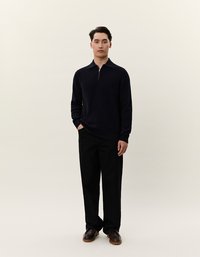 Marineblauer Pullover mit Reißverschlusskragen, aus strukturiertem Material, kombiniert mit schwarzen geraden Hosen und braunen Schuhen. Einfaches, modernes Design.