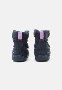 Σκούρες μπλε σουέτ μπότες με μωβ υφασμάτινη περιλαίμιση, υφή από καουτσούκ στη σόλα και κλείσιμο με λουράκι και θηλιά για εύκολη χρήση.