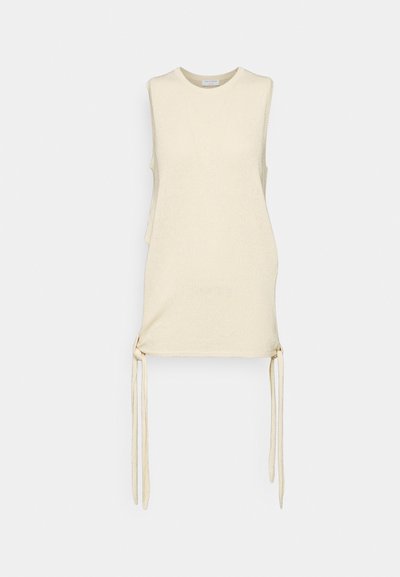 Ujjatlan krémszínű felső, texturált anyagból készült, oldalsó megkötőkkel az állítható illeszkedés érdekében és kerek nyakkivágással. Könnyű és laza kialakítás.