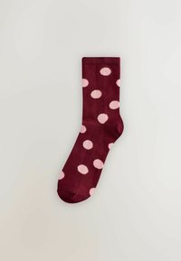Chaussettes bordeaux avec des pois roses, fabriquées en tissu lisse. Elles présentent un bord-côte côtelé et un orteil renforcé pour plus de durabilité.