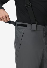 Grau farbene Hose mit verstellbarem Bund, ausgestattet mit Klettverschluss und Knopfverschlüssen. Der Stoff wirkt glatt und hat seitliche Taschen.