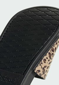 Czarna gumowa podeszwa z teksturowanym wzorem gwarantującym przyczepność, z brązowym paskiem w leopardzi wzór. Podkreśleniem jest logotyp marki na podeszwie.
