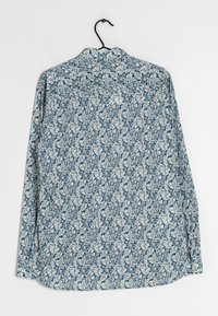 Camicia a maniche lunghe con motivo foglie blu e bianche. Realizzata in tessuto leggero, presenta un orlo arrotondato e colletto standard.