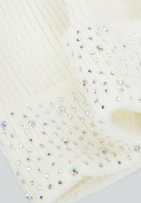 Sciarpa bianca lavorata a maglia con costine testurizzate e strass trasparenti distribuiti in modo sparso, che aggiungono scintillio e profondità al design.