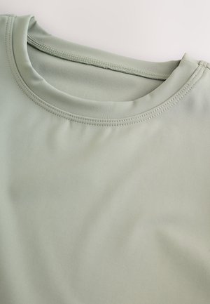 Lichtgroen shirt met korte mouwen en een ronde halslijn. Zachte, gladde stof met zichtbare stikseldetails rond de kraag.