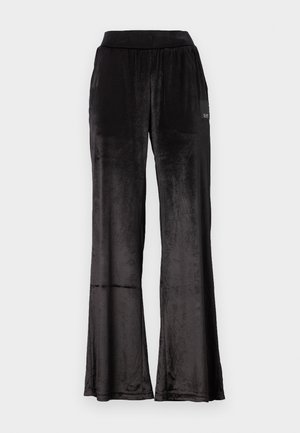 Zwarte, fluwelen loungebroek met een wijd beenontwerp en een elastische tailleband. Bevat een klein merkaccent aan de zijkant. Zachte textuur.