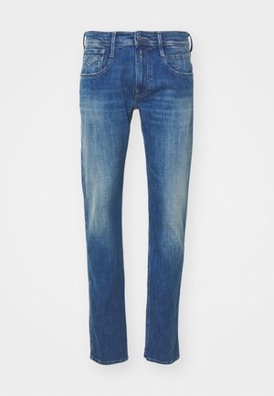 Kék farmernadrág, egyenes láb kialakítással, kopott hatással, öt zsebes stílussal és fém kiegészítőkkel a gombnál és a cipzárnál.