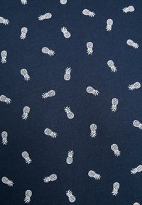 Tela azul marino con un patrón repetido de pequeñas piñas blancas, hecha de algodón suave con una textura lisa.