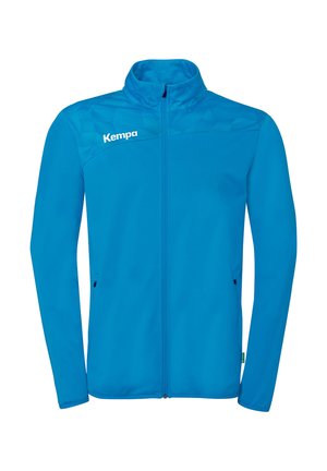 Blå jakke med fuld lynlås og opretstående krave, lange ærmer, geometrisk mønster på øvre bryst og "Kempa" logo på venstre skulder.