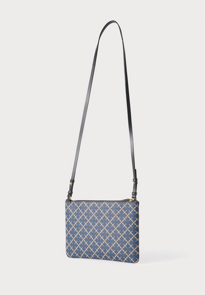 Sac à motifs géométriques bleus avec fermeture zippée, bandoulière en cuir noir et accents dorés. Forme rectangulaire avec surfaces texturées.