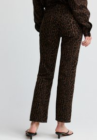 Hlače s leopard uzorkom u tamnosmeđoj i crnoj boji, visoki struk, ravne nogavice, izrađene od mekog materijala, s stražnjim džepovima i minimalnim hardverom.