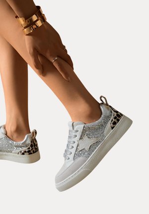 Baskets argentées et grises avec des accents en paillettes et un talon imprimé léopard, dotées de lacets et d'un design en forme d'étoile sur le côté. Semelle en caoutchouc.