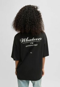 Black oversized t-shirt with white text on the back reading "Whatever I’m Getting Fries." Soft cotton material. Relaxed fit.