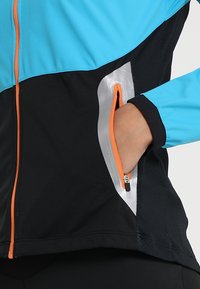 Jacket featuring a blue upper section and black lower body, with an orange zipper, silver accents, and a side zippered pocket.
