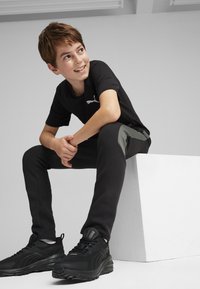 Puma EVOSTRIPE YOUTH - Pantalones deportivos - black