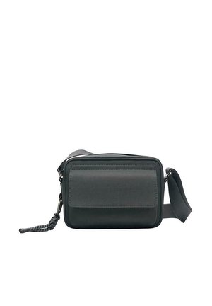 Kleine schwarze Umhängetasche mit einer Vorderklappe, Reißverschluss, verstellbarem Riemen und geflochtenem Quasten-Detail am Reißverschluss.