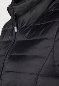 Sort pufferjakke med høj krave, der har quiltede sektioner, en centrallukning med lynlås og en snor til justering i kraven.