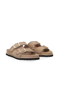 Beige sandals with two adjustable straps, gold metal buckles, and brown stitching on soft material. Textured black rubber outsole.