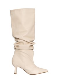 Beige leren laars tot halverwege de kuit met een losse pasvorm, puntige neus en lage kittenhak, zijkant weergegeven op een witte achtergrond.