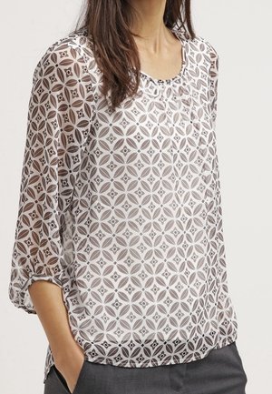 Blusa trasparente con un motivo geometrico bianco e marrone, dotata di scollatura a girocollo e maniche a tre quarti, con una vestibilità ampia.