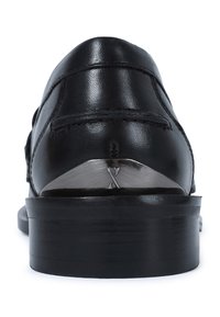Zapato de cuero negro con punta redondeada, que presenta acentos metálicos en el tacón y una textura suave, destacando un diseño elegante.