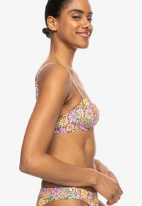 Top de bikini con estampado floral en colores pastel, que presenta finas correas ajustables y una textura de tela suave con una forma estructurada.