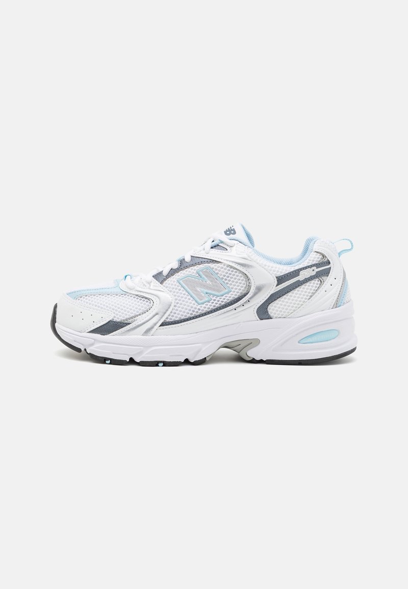 Chaussure de course New Balance blanche et bleu clair avec une tige en mesh et synthétique, une semelle épaisse et une fermeture à lacets, vue de côté.